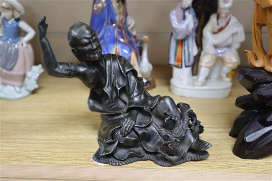 A Chinese wood carving, two Chinese porcelain figures and a bronze